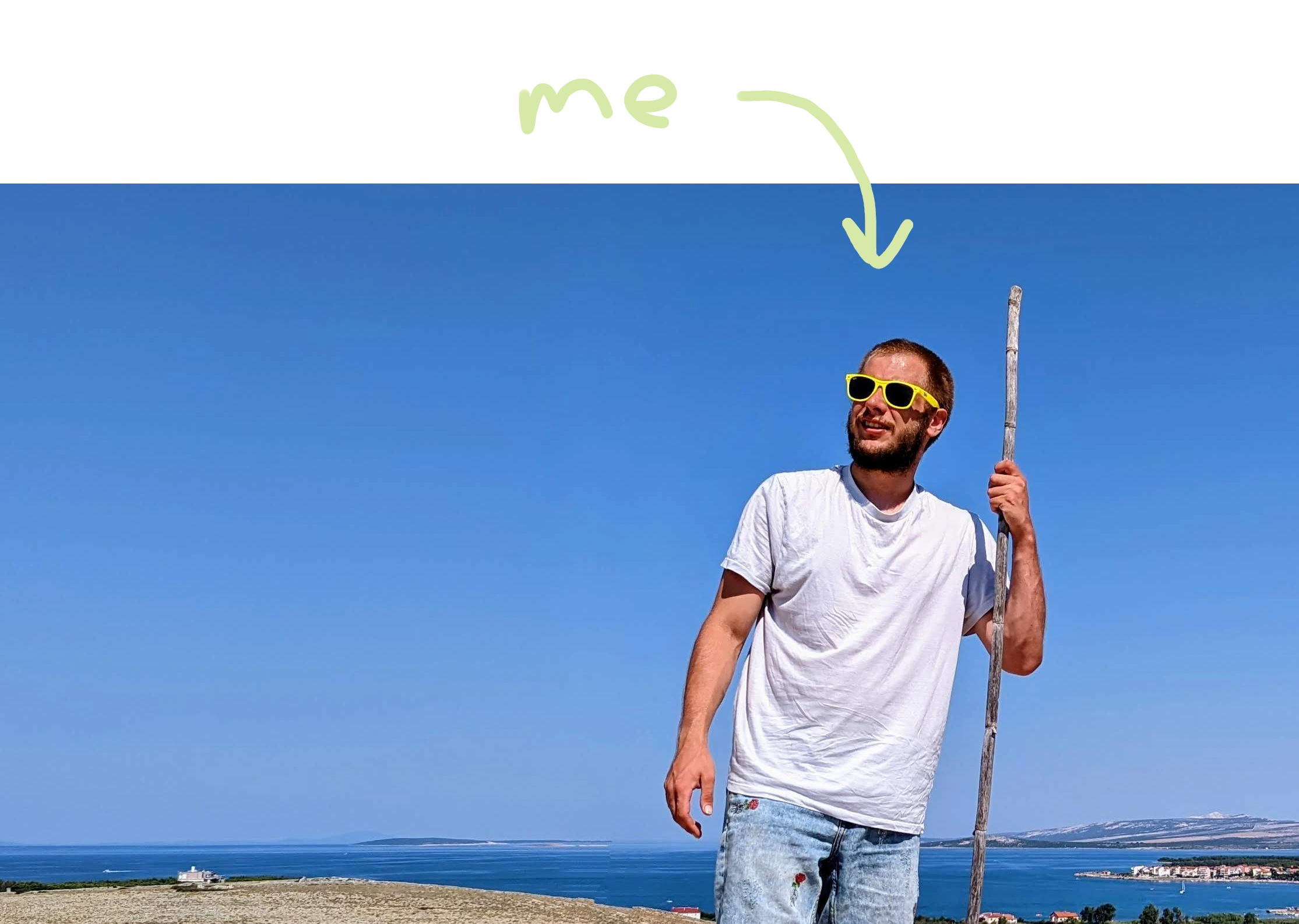 A picture of Mario Borna Mjertan, holding a branch while looking into the sky with yellow sunglasses. Behind him, the coastline and the sea are visible.